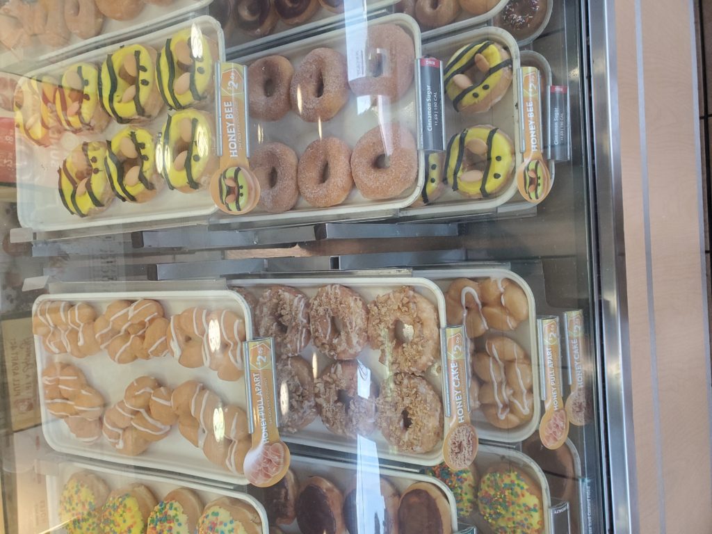 Pans of donuts in glass display case