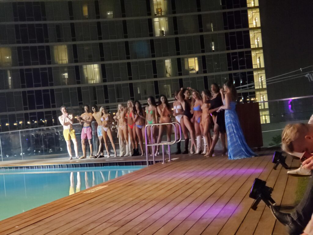 Group of models posing in swim suits as a group at end of show