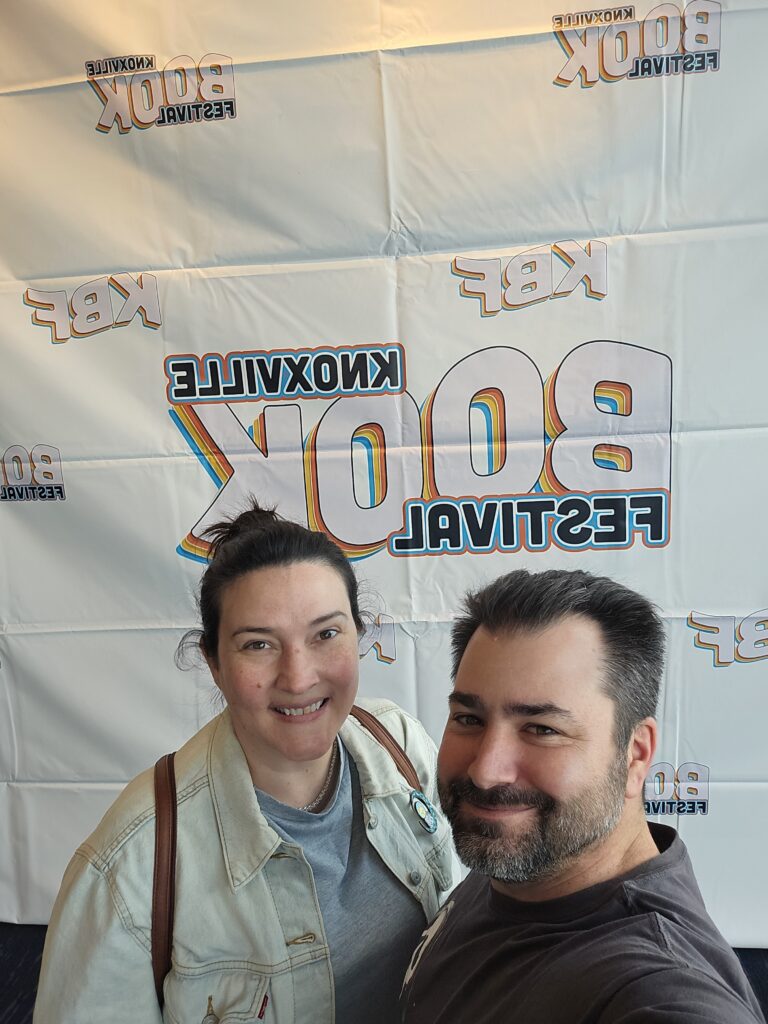 Couple in front of event backdrop